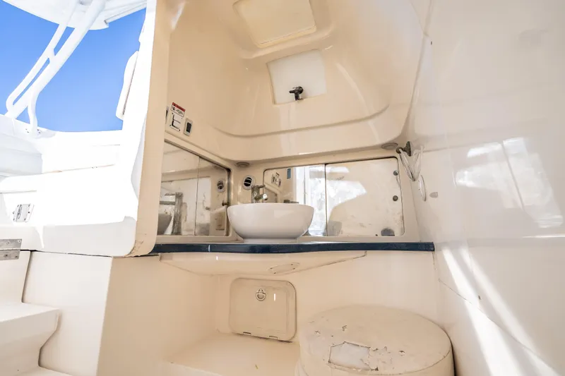 Slide: The Image of Interior of 2016 Intrepid 375 Center Console boat featuring a compact bathroom area. - 29