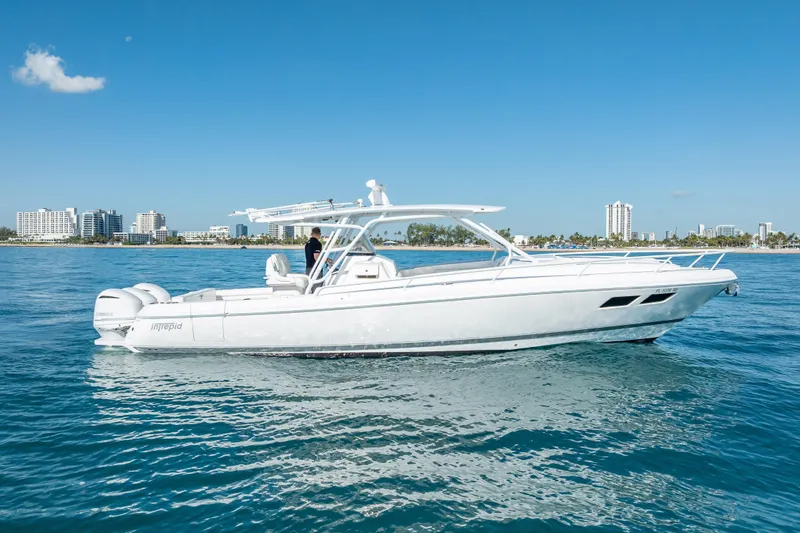 Slide: The Image of 2016 Intrepid 375 Center Console boat cruising on clear blue water near city skyline. - 3
