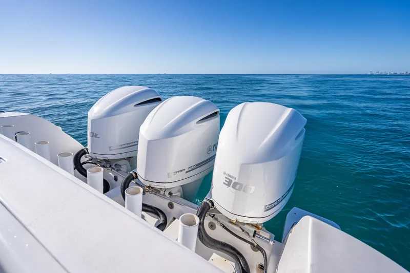 Slide: The Image of Triple Yamaha outboard engines on a 2016 Intrepid 375 Center Console boat in open water. - 32