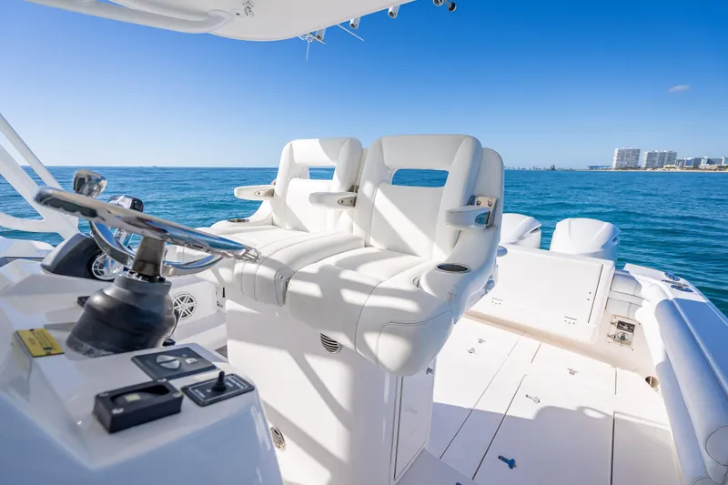 Slide: The Image of 2016 Intrepid 375 Center Console boat interior with white seating and steering wheel. - 48