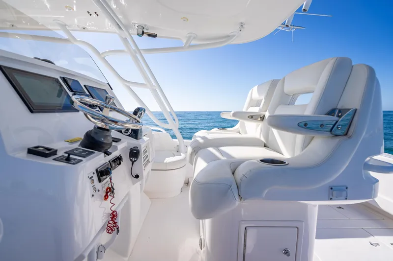 Slide: The Image of 2016 Intrepid 375 Center Console boat interior with steering wheel and seating, ocean view. - 49