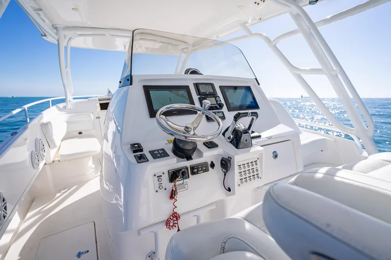 Slide: The Image of 2016 Intrepid 375 Center Console boat interior with steering wheel and navigation screens. - 50