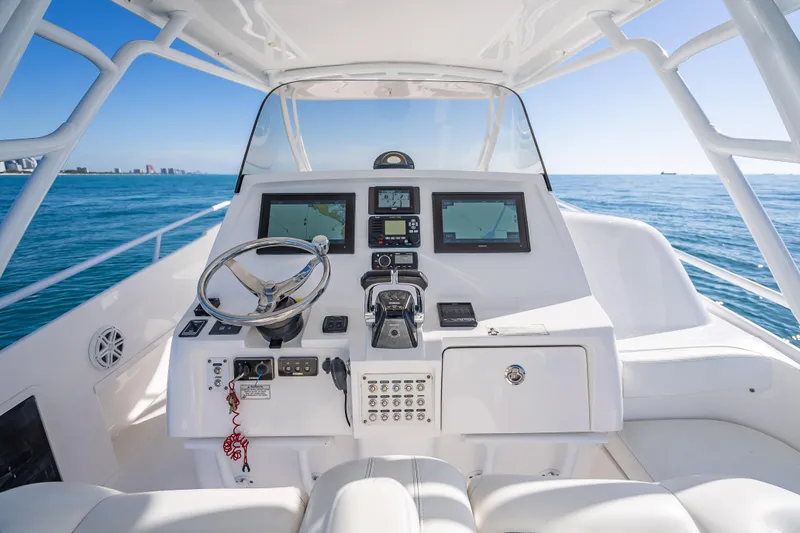 Slide: The Image of 2016 Intrepid 375 Center Console helm with navigation screens, steering wheel, and ocean view. - 51