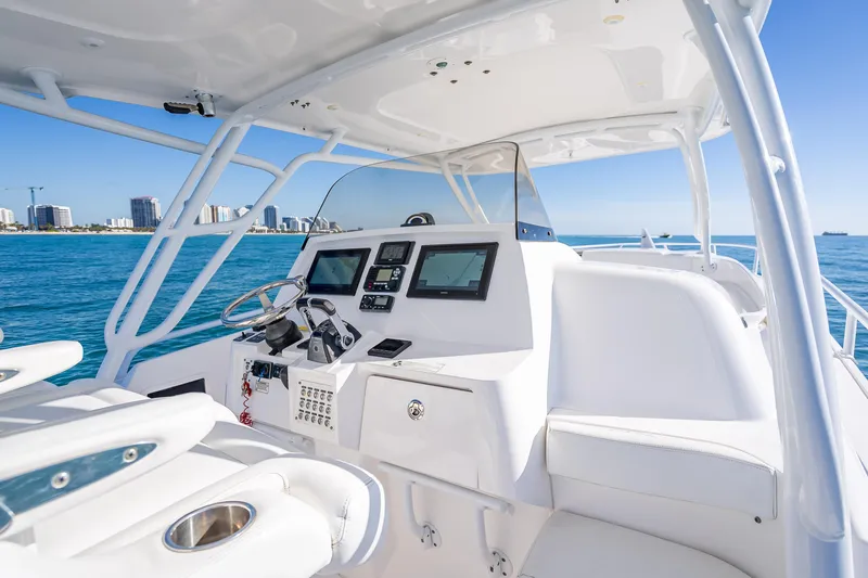 Slide: The Image of 2016 Intrepid 375 Center Console boat interior with modern navigation equipment, cruising on blue ocean waters. - 53