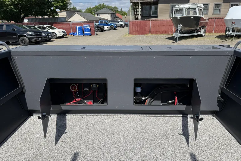 Slide: The Image of 2026 Alumaweld Intruder 22 boat interior with open storage compartments, parked outdoors. - 20