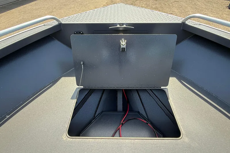 Slide: The Image of 2026 Alumaweld Intruder 22 boat storage compartment with open hatch and visible wiring. - 24