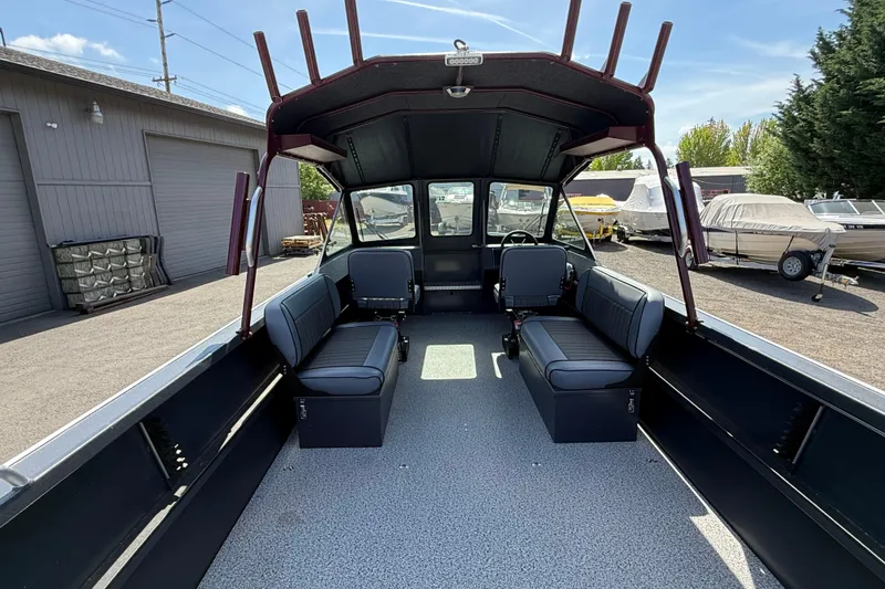 Slide: The Image of 2026 Alumaweld Intruder 22 boat interior with seating and steering wheel, parked outdoors. - 4