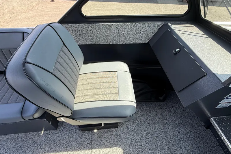 Slide: The Image of 2026 Alumaweld Intruder 22 interior with gray seating and storage compartment. - 9