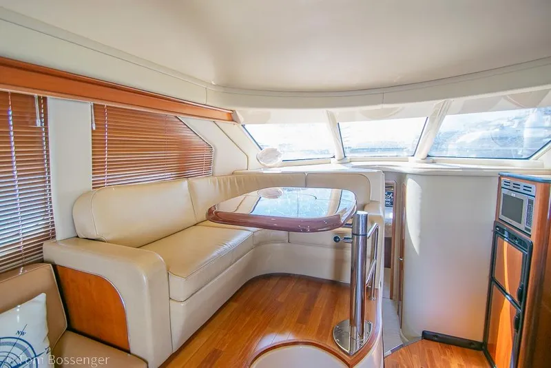 Slide: The Image of Luxurious interior of 2005 Sea Ray 420 Sedan Bridge with elegant seating and wooden accents. - 10