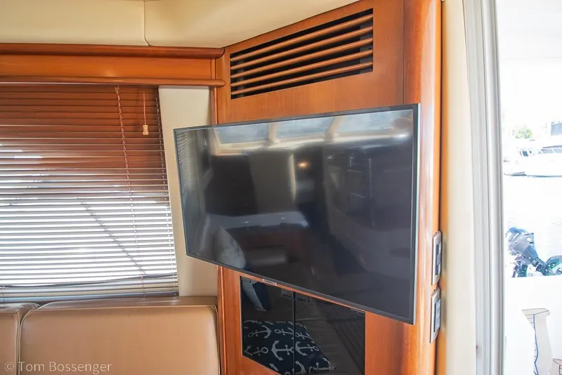 Slide: The Image of Interior of 2005 Sea Ray 420 Sedan Bridge with mounted TV and wooden blinds. - 15