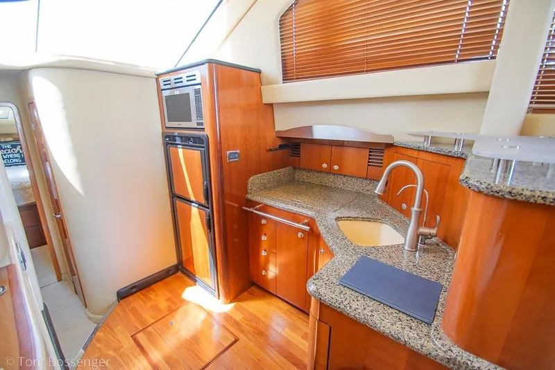 Slide: The Image of Luxurious 2005 Sea Ray 420 Sedan Bridge yacht kitchen with wood cabinetry and modern appliances. - 16