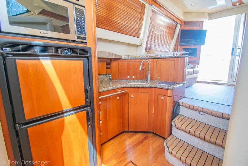 Slide: The Image of Luxurious 2005 Sea Ray 420 Sedan Bridge yacht interior with modern kitchen and wooden cabinetry. - 17