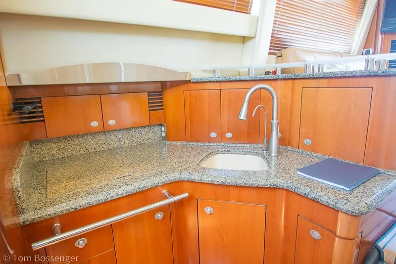 Slide: The Image of Luxurious 2005 Sea Ray 420 Sedan Bridge yacht kitchen with granite countertops and wooden cabinetry. - 19