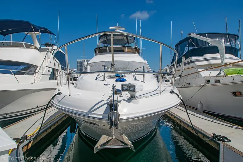 Slide: The Image of 2005 Sea Ray 420 Sedan Bridge yacht docked at marina under clear blue sky. - 2