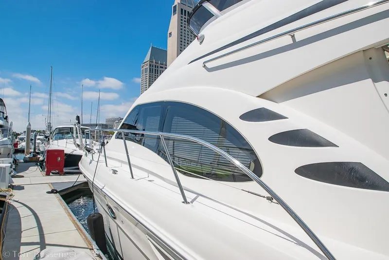 Slide: The Image of 2005 Sea Ray 420 Sedan Bridge yacht docked at marina under clear blue sky. - 3