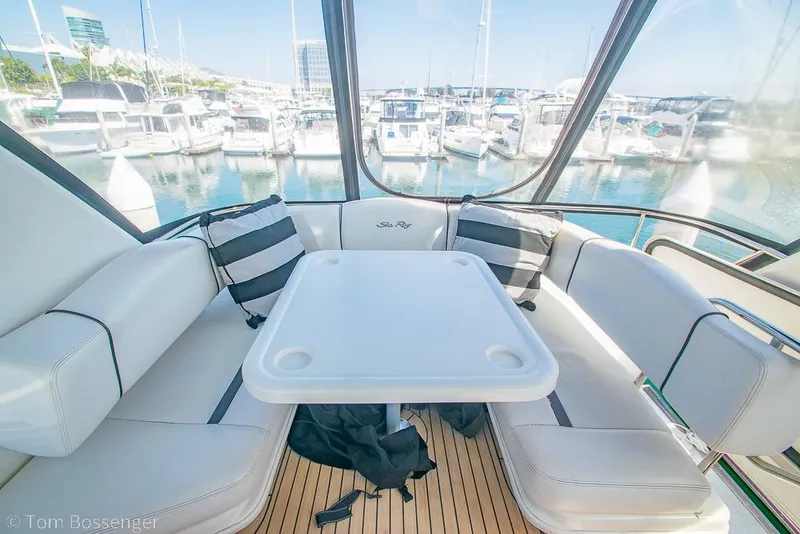 Slide: The Image of 2005 Sea Ray 420 Sedan Bridge interior with seating and table, overlooking marina. - 50