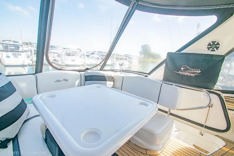 Slide: The Image of 2005 Sea Ray 420 Sedan Bridge interior with seating and table, docked at marina. - 51
