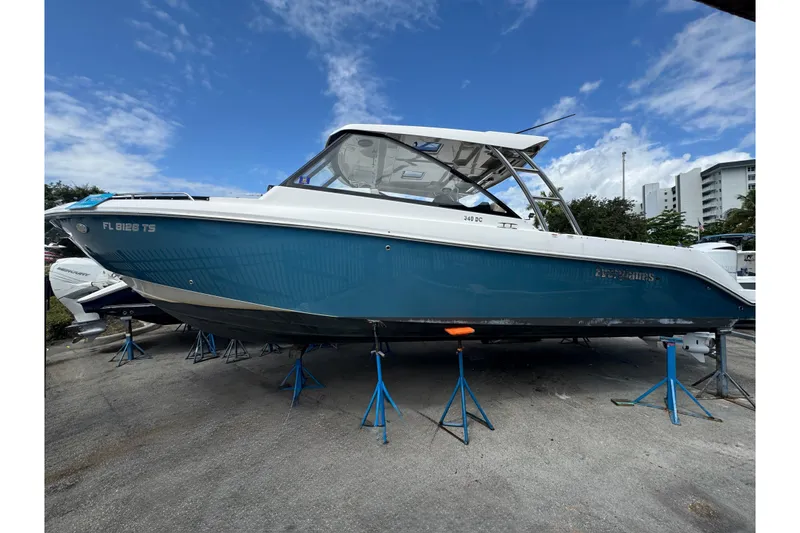The Image of 2019 Everglades 340 Dual Console boat on stands, blue hull, clear sky background. - 0