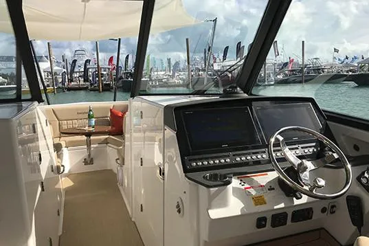 Slide: The Image of Manufacturer Provided Image: 2019 Everglades 340 Dual Console boat interior with modern dashboard and waterfront view. - 12