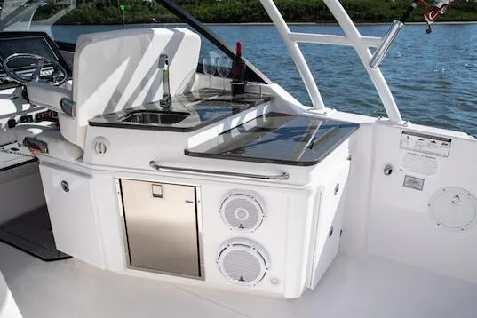 Slide: The Image of Manufacturer Provided Image: 2019 Everglades 340 Dual Console boat interior with kitchenette and water view. - 13