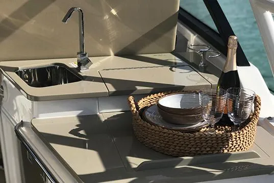 Slide: The Image of Manufacturer Provided Image: 2019 Everglades 340 Dual Console boat kitchen with sink, champagne, and tableware. - 16