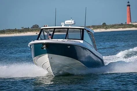 Slide: The Image of Manufacturer Provided Image: 2019 Everglades 340 Dual Console boat cruising on water near a lighthouse. - 3