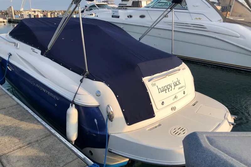 Slide: The Image of 2006 Monterey 250 Cruiser docked, covered with navy blue tarp, named "The Happy Jack." - 5