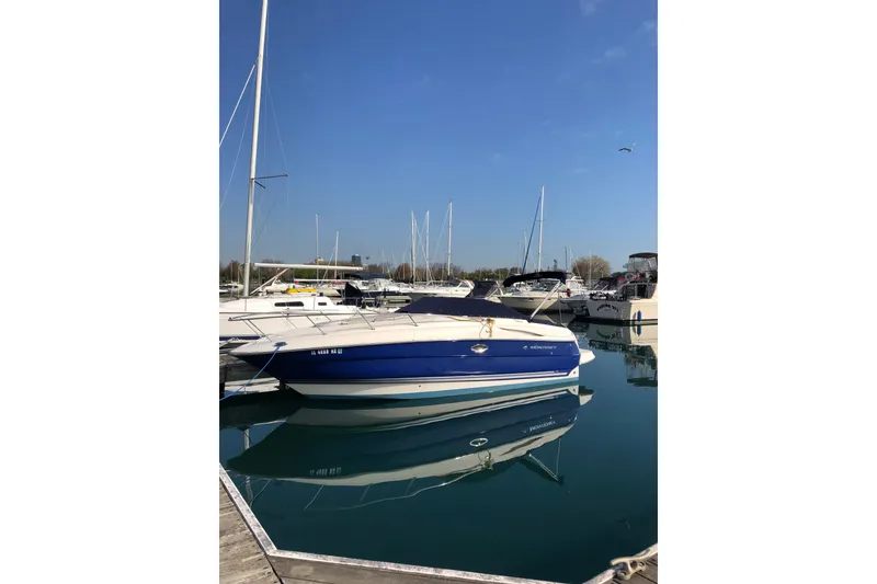Slide: The Image of 2006 Monterey 250 Cruiser boat docked in a marina under clear blue skies. - 9
