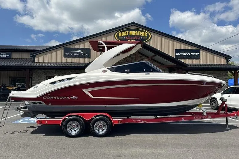 The Image of 2015 Chaparral 257 SSX boat on trailer at dealership, red and white design. - 0