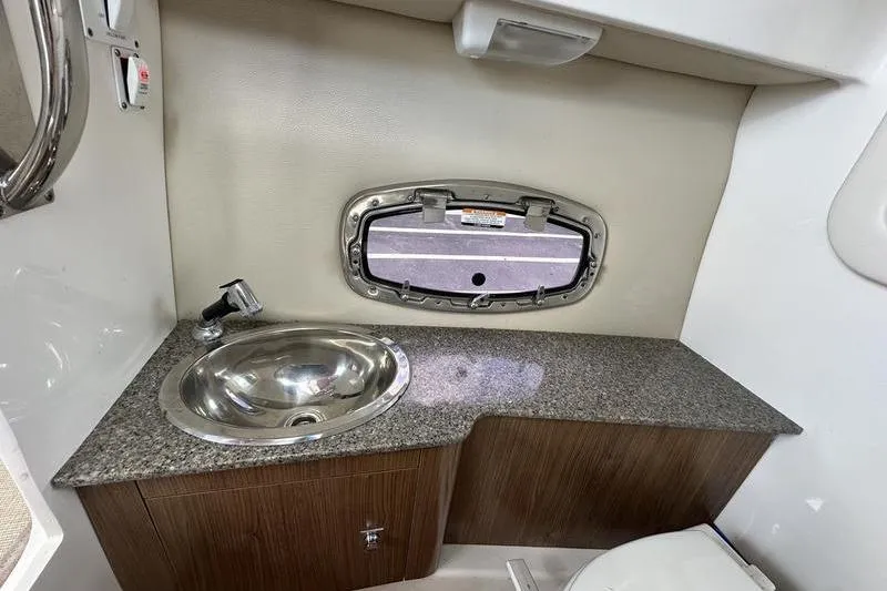 Slide: The Image of 2015 Chaparral 257 SSX boat interior with sink, countertop, and porthole window. - 12