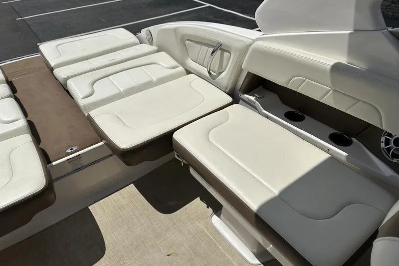 Slide: The Image of 2015 Chaparral 257 SSX boat interior with beige seating and cup holders. - 24