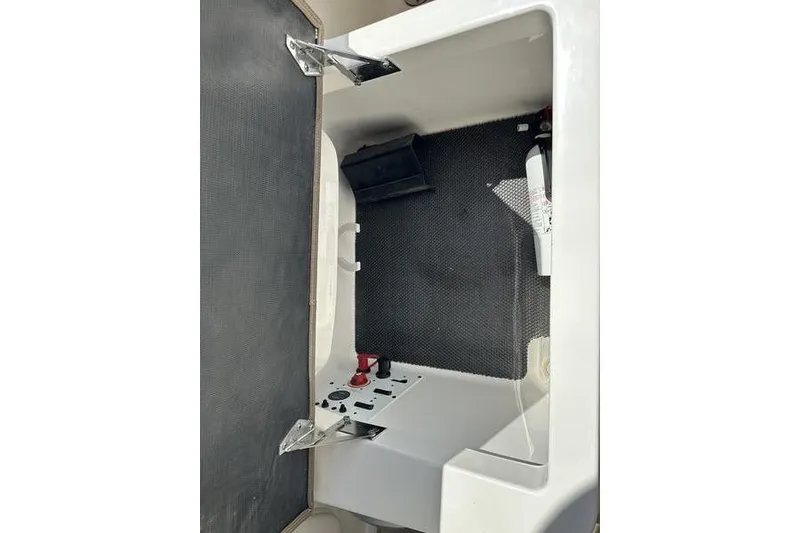 Slide: The Image of Interior storage compartment of a 2015 Chaparral 257 SSX boat, featuring safety equipment. - 28