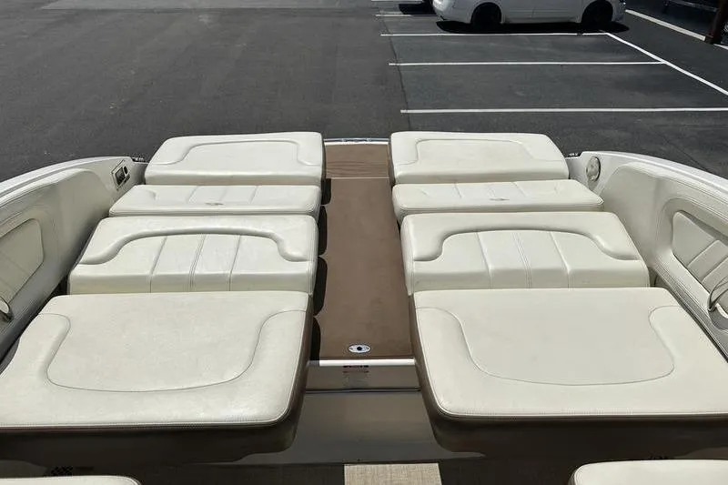 Slide: The Image of 2015 Chaparral 257 SSX boat with spacious white seating in a parking lot. - 29