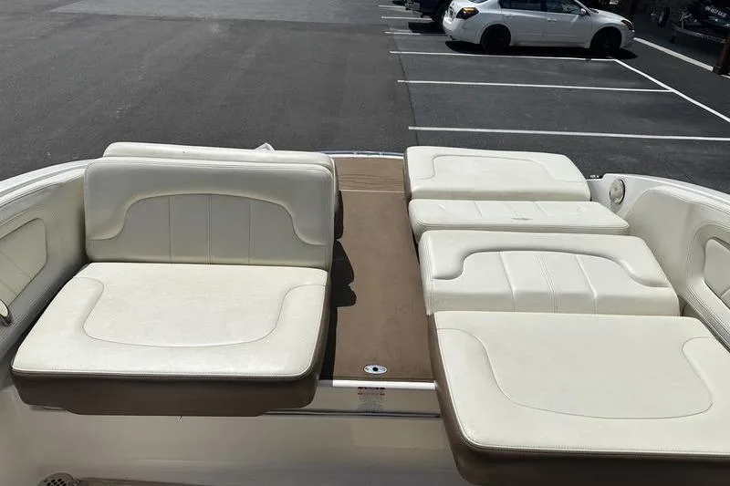 Slide: The Image of 2015 Chaparral 257 SSX boat interior with white cushioned seating in a parking lot. - 31