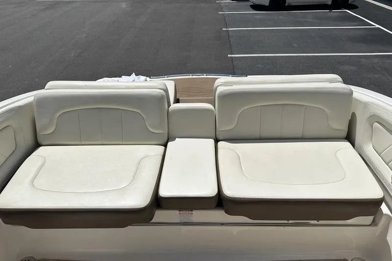 Slide: The Image of 2015 Chaparral 257 SSX boat seating, featuring white cushioned seats in a parking lot. - 33