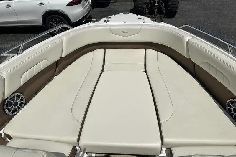 Slide: The Image of 2015 Chaparral 257 SSX boat interior with beige seating and speakers. - 38
