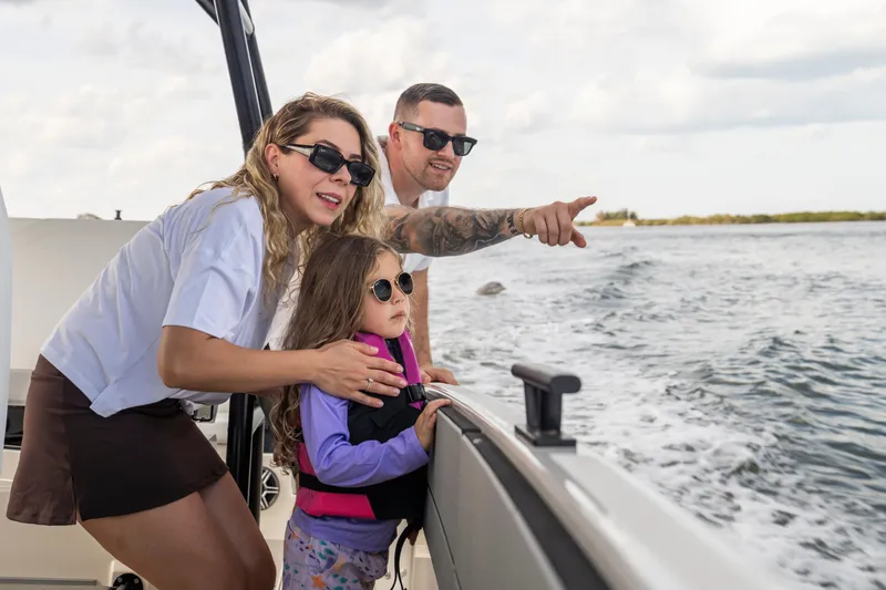 Slide: The Image of Family enjoying a boat ride on a 2027 Navan T30, pointing at the scenic view. - 11
