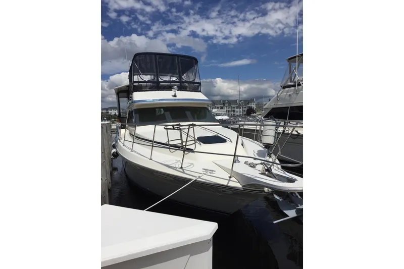Slide: The Image of 1987 Sea Ray 410 Aft Cabin yacht docked under a partly cloudy sky. - 2