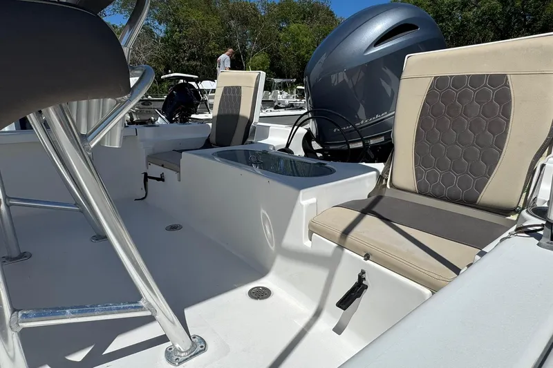 Slide: The Image of 2018 Tidewater 1910 Bay Max boat interior with seating and motor, outdoors. - 10