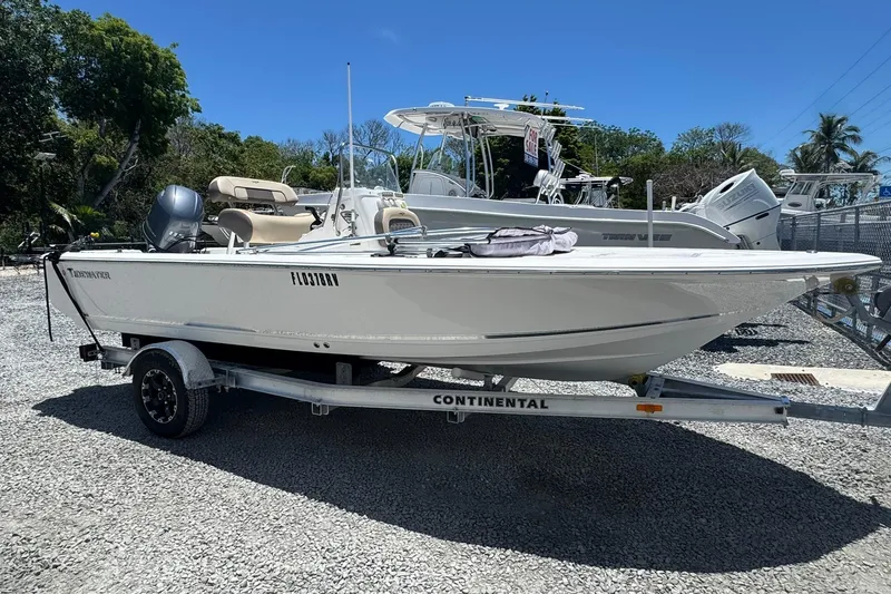 Slide: The Image of 2018 Tidewater 1910 Bay Max boat on trailer, parked outdoors under clear blue sky. - 15