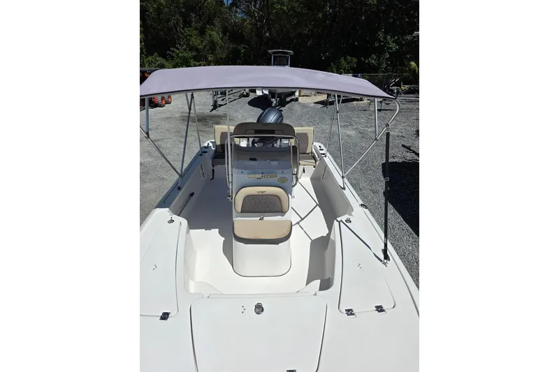 Slide: The Image of 2018 Tidewater 1910 Bay Max boat with canopy, parked on gravel, surrounded by trees. - 7