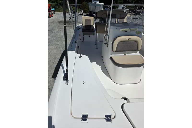 Slide: The Image of 2018 Tidewater 1910 Bay Max boat interior with seating and console, parked on gravel. - 8