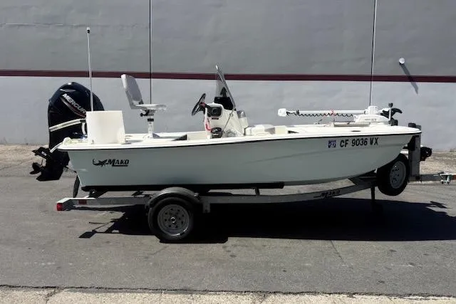 Slide: The Image of 2024 Mako Pro Skiff 13 CC boat on trailer, parked outdoors. - 11