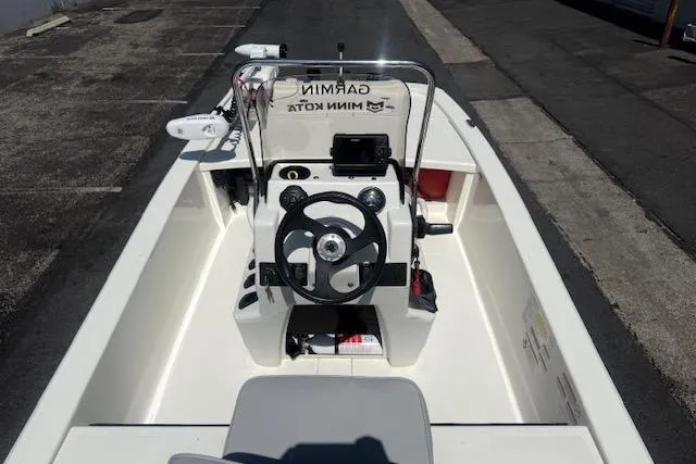 Slide: The Image of 2024 Mako Pro Skiff 13 CC boat interior with steering wheel and navigation equipment. - 17