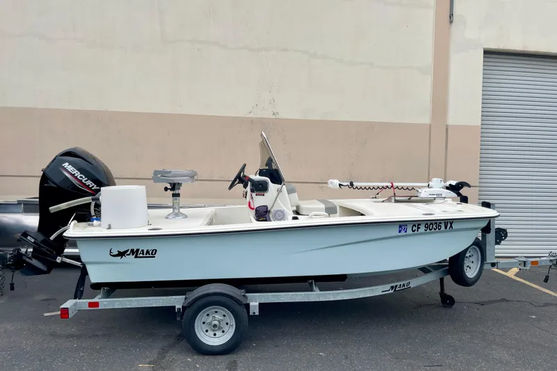 Slide: The Image of 2024 Mako Pro Skiff 13 CC boat on trailer with Mercury outboard motor. - 6