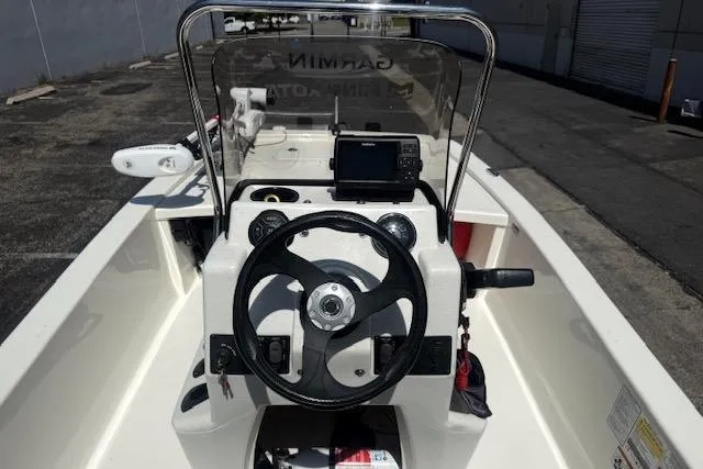 Slide: The Image of 2024 Mako Pro Skiff 13 CC boat dashboard with steering wheel and navigation equipment. - 7