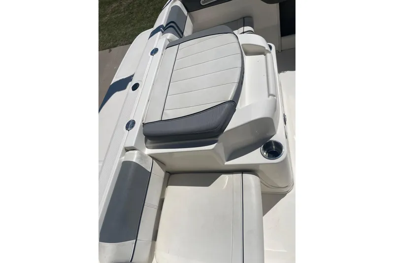 Slide: The Image of 2015 Bayliner 185 Bowrider boat interior seating with cup holder, featuring white and gray upholstery. - 9