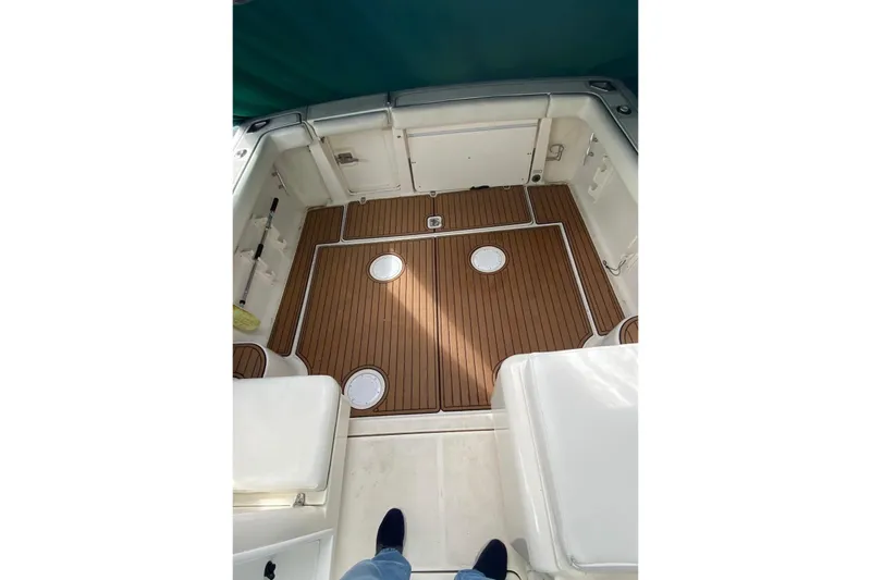 Slide: The Image of 2001 Pursuit 3000 Express boat interior with teak flooring and white seating. - 10