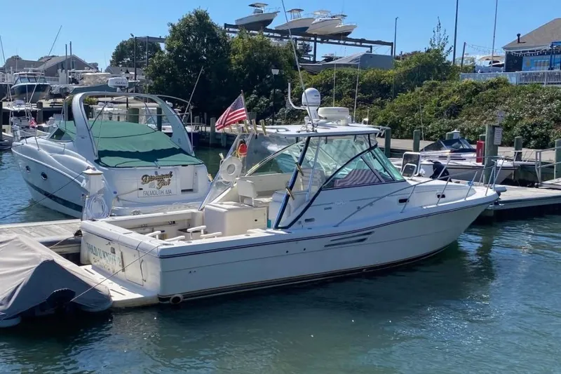 Slide: The Image of 2001 Pursuit 3000 Express boat docked at marina with American flag. - 2