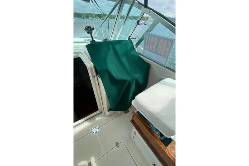 Slide: The Image of 2001 Pursuit 3000 Express boat interior with "For Sale" sign, green cover, and white seat. - 6
